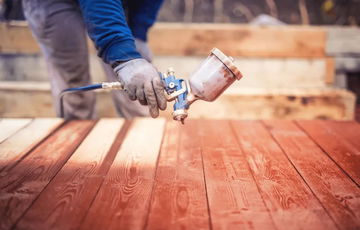 A deck being sprayed with stain