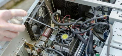 hand using compressed air on computer